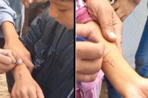 children in gaza writing their names on their arms